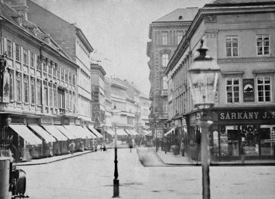 A V�ci utca a Gizella (ma: V�r�smarty) t�r fel�l. Jobb oldalt a Drasche-h�z m�g�tt emelkedik az 1869-ben szab�lyellenesen �p�lt n�gyemeletes lak�h�z. Vele szemben a r�gi Pest egyik nevezetess�g�t, a Nagy Krist�f-szobrot l�tjuk. 1870-es �vek els� fele. Ismeretlen f�nyk�p�sz felv�tele. Budapesti T�rt�neti M�zeum
